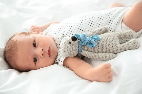 Чарівна новонароджена дитина з іграшкою лежить на простирадлі — стокове фото
