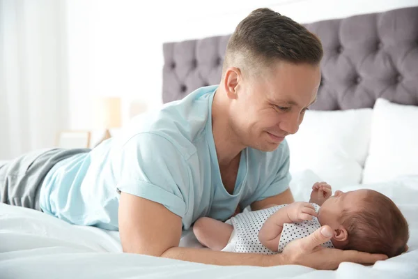 Mannen med sin nyfödda baby på säng — Stockfoto