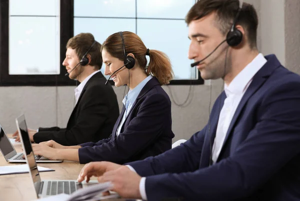 Technisches Support-Team mit Headsets am Arbeitsplatz — Stockfoto