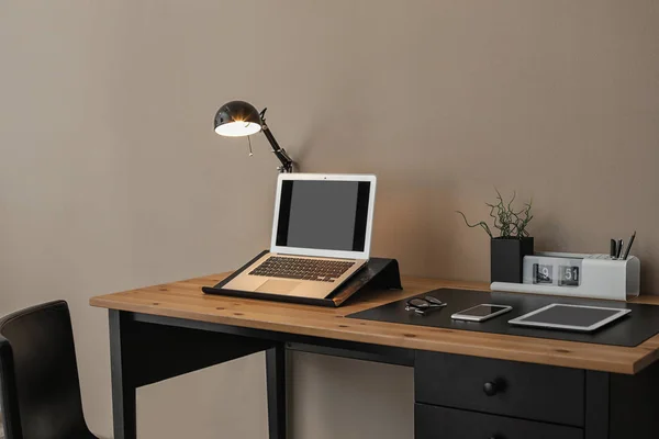 Interior moderno del lugar de trabajo con ordenador portátil y dispositivos en la mesa. Espacio para texto —  Fotos de Stock