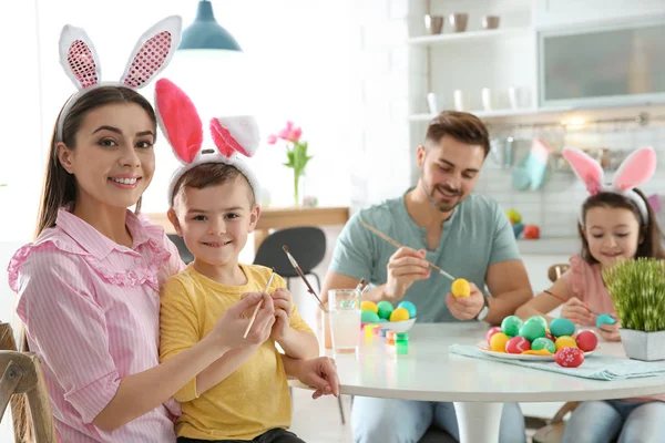 Glückliche Familie bemalt Ostereier in der Küche. Festliche Tradition — Stockfoto