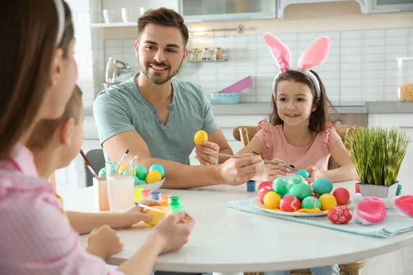Lycklig familj måla påskägg i köket. Festlig tradition — Stockfoto