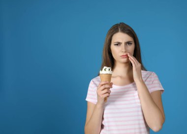 Hassas dişler ve dondurma renk arka plan üzerinde duygusal genç kadınla. Metin için yer