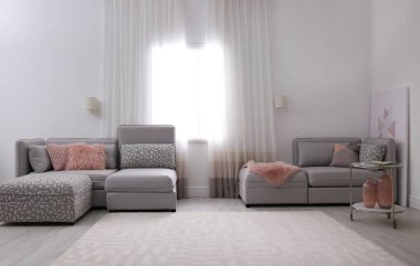 Pencereye yakın rahat kanepesi olan modern oturma odası.