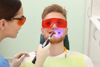 Profesyonel diş hekimi modern klinik hasta ile çalışma. Diş beyazlatma