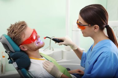 Profesyonel diş hekimi modern klinik hasta ile çalışma. Diş beyazlatma
