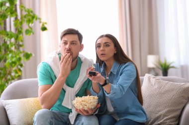 Oturma odasında patlamış mısır ile film izlerken Çift