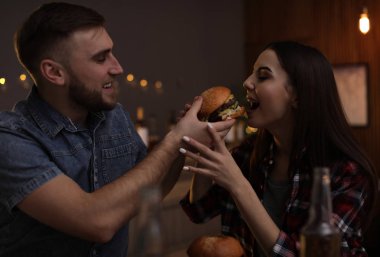 Genç çift burger restoranda öğle yemeği