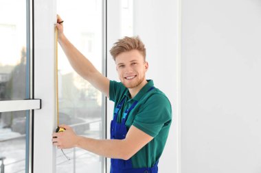 içerideki kurulum için pencereyi ölçen servis elemanı