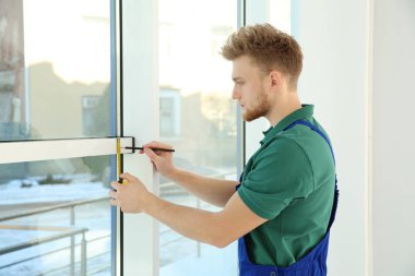 içerideki kurulum için pencereyi ölçen servis elemanı