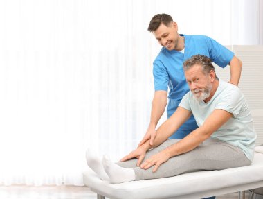 Fizyoterapist hastada klinik, metin için yer ile çalışma. Rehabilitasyon tedavisine