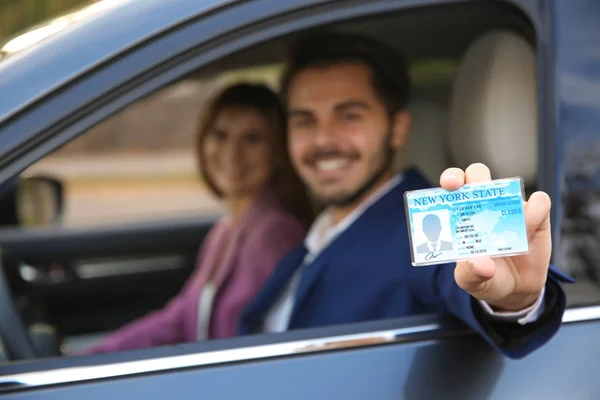 Jovem com carta de condução no carro com passageiro. Espaço para texto — Fotografia de Stock