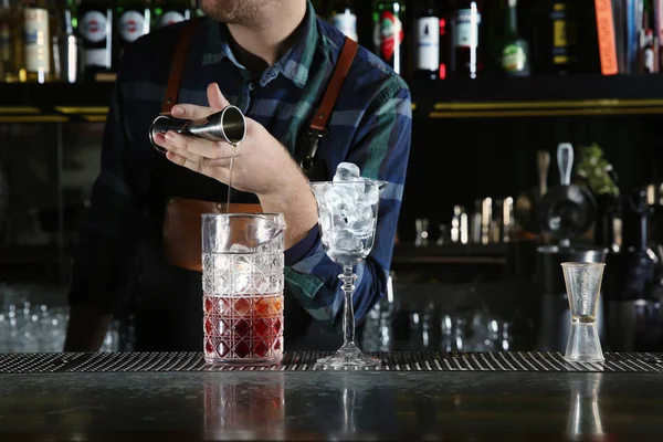 Barman derramando ingredientes de coquetel em vidro de mistura no balcão no pub, close-up — Fotografia de Stock