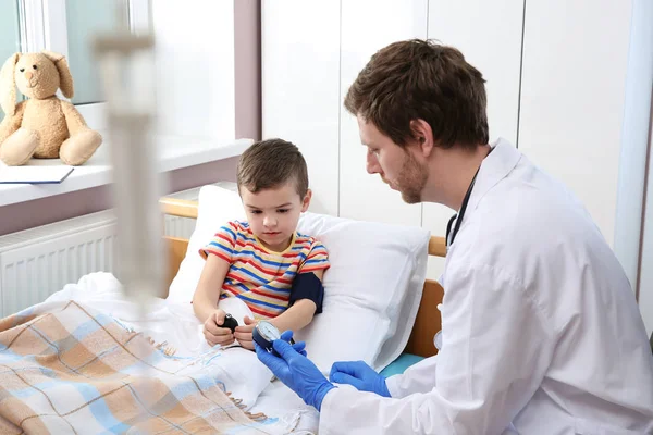 Médico revisando la presión arterial del niño en el hospital — Foto de Stock