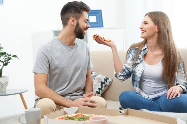 年轻夫妇在客厅吃披萨吃午饭。食品配送 — 图库照片