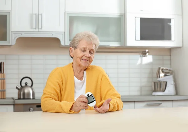 Vezető nő használ digitális glükométer otthon. Cukorbetegség ellenőrzése — Stock Fotó