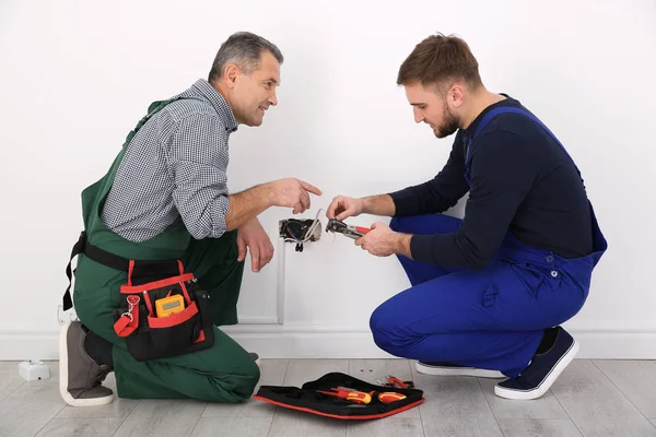 Senior-Elektriker hilft Auszubildender beim Abisolieren von Draht — Stockfoto