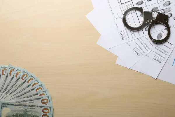 Χρήματα, χειροπέδες και δακτυλικών αποτυπωμάτων φυλλα σε ξύλινα φόντο, το top view με χώρο για κείμενο. Ποινική έρευνα — Φωτογραφία Αρχείου