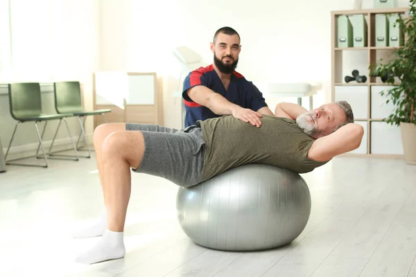 Fisioterapeuta trabalhando com paciente na clínica. Terapia de reabilitação — Fotografia de Stock