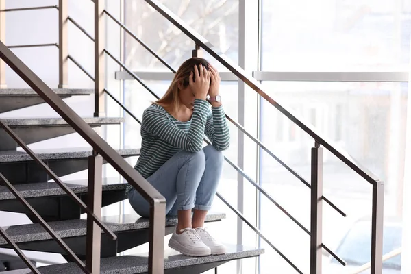 Menina adolescente emocional sentado em escadas dentro de casa — Fotografia de Stock