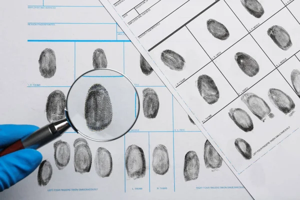Criminalista estudiando huellas dactilares con lupa, vista superior —  Fotos de Stock