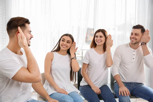 Groep jongeren leren van gebarentaal met leraar binnenshuis — Stockfoto