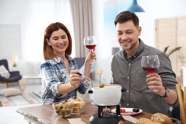 Happy couple enjoying fondue dinner at home — Stock Photo, Image