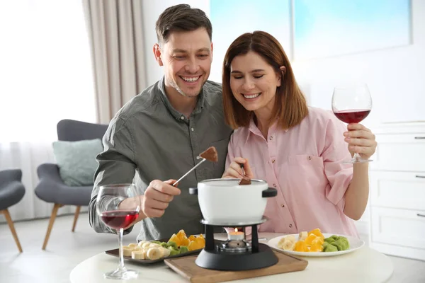 Pareja feliz disfrutando de la cena fondue en casa — Foto de Stock