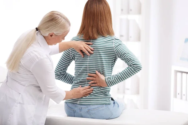 Chiropractor examining patient with back pain in clinic — Stock Photo, Image
