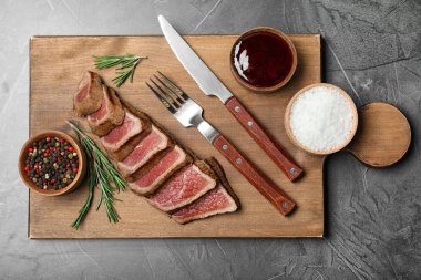 Kavrulmuş et, sosu ile baharat gri arka plan, üstten görünüm üzerinde ahşap tahta