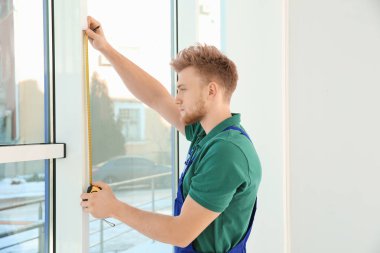 içerideki kurulum için pencereyi ölçen servis elemanı