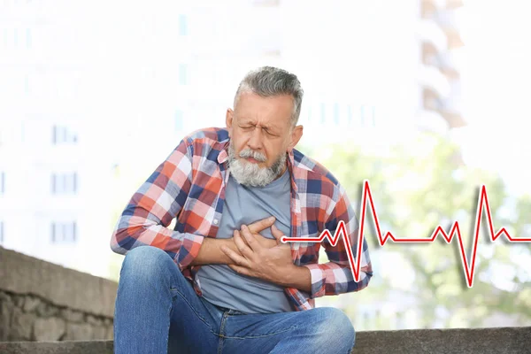 Senior mannen lider av hjärtattack utomhus — Stockfoto