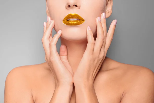 Gyönyörű fiatal nő, arany színű háttér, Vértes ajkak — Stock Fotó