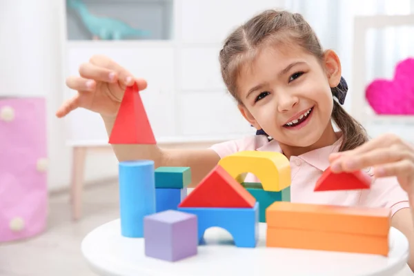 Мила дитина грає з барвистими блоками вдома — стокове фото