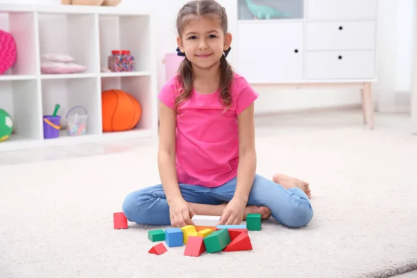 Lindo niño jugando con bloques de colores en el suelo en casa — Foto de Stock