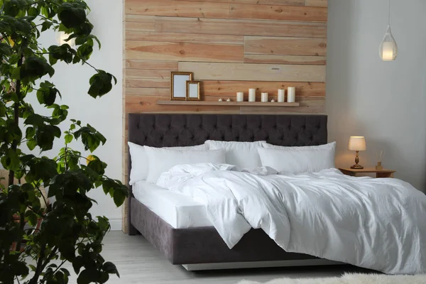 Grande cama confortável no quarto elegante. Design de interiores moderno — Fotografia de Stock