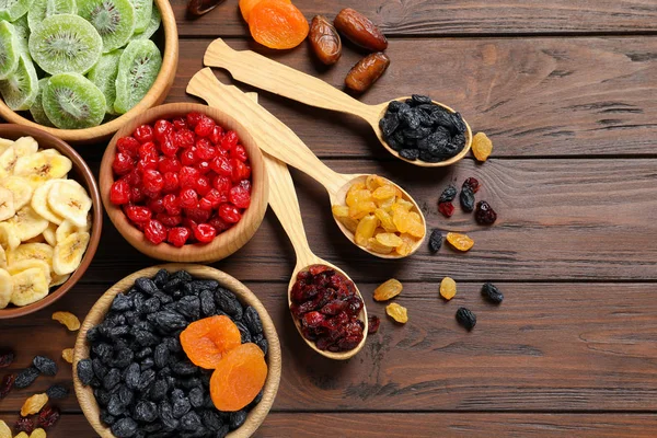 Composição de leigos plana com frutas secas diferentes em fundo de madeira, espaço para texto. Estilo de vida saudável — Fotografia de Stock