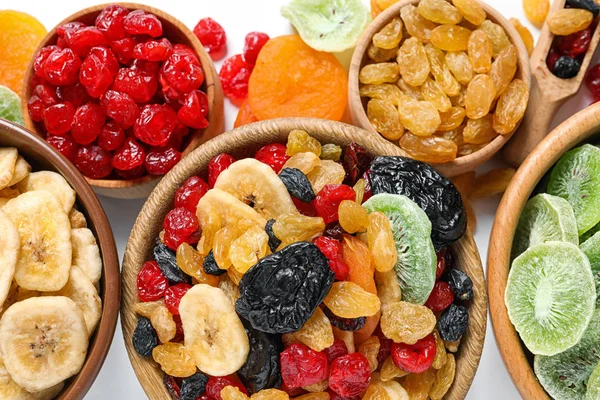 Ciotole con diversi frutti secchi su sfondo bianco, posa piatta. Stile di vita sano — Foto Stock