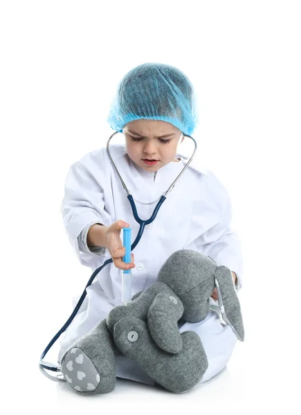 Schattig kind spelen arts met gevulde speelgoed op witte achtergrond — Stockfoto