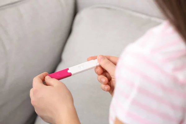 Mujer joven con prueba de embarazo en el interior, primer plano. Ginecología y parto — Foto de Stock