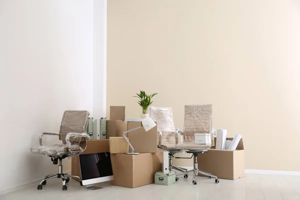 Moving boxes and furniture in new office. Space for text — Stock Photo, Image