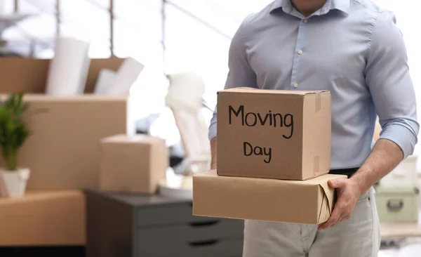 Un hombre moviendo cajas en una oficina nueva, de cerca. Espacio para texto — Foto de Stock