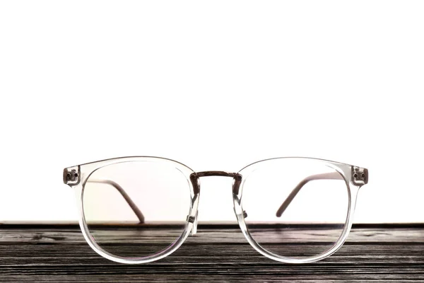 Gafas sobre mesa de madera sobre fondo blanco. Consulta al oftalmólogo — Foto de Stock