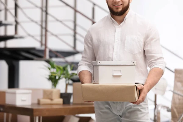 Un hombre moviendo cajas en una oficina nueva, de cerca. Espacio para texto — Foto de Stock