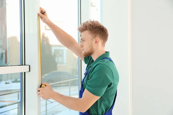 Servicekraft misst Fenster für den Einbau in Innenräume — Stockfoto