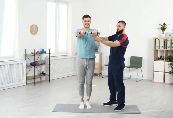 Sjukgymnast som arbetar med patienten i klinik. Rehabilitering terapi — Stockfoto