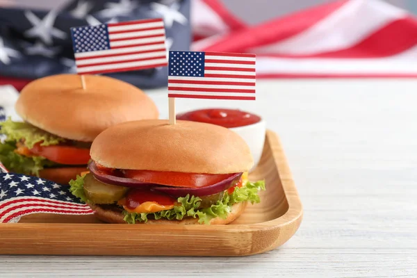 Смачні гамбургери з прапорами США служив на столі, простір для тексту. Традиційні американські страви — стокове фото