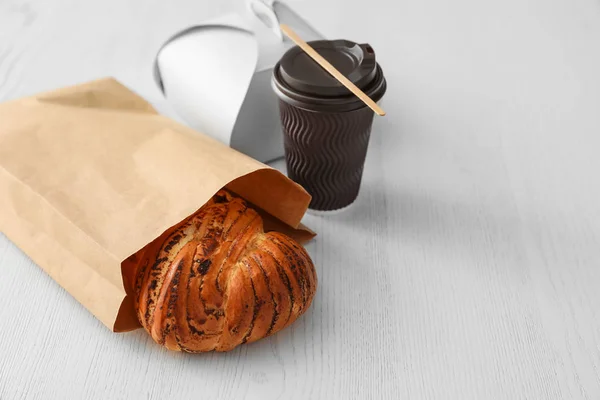 Bolsa de papel con pastelería y comida para llevar en mesa de madera. Espacio para texto — Foto de Stock