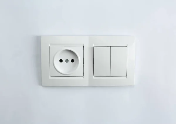 Light switch and power socket on white background. Electrician\'s equipment