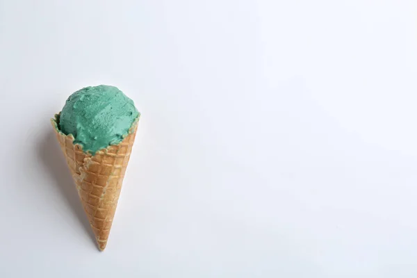 Delicioso sorvete spirulina em cone de waffle no fundo branco, vista superior — Fotografia de Stock